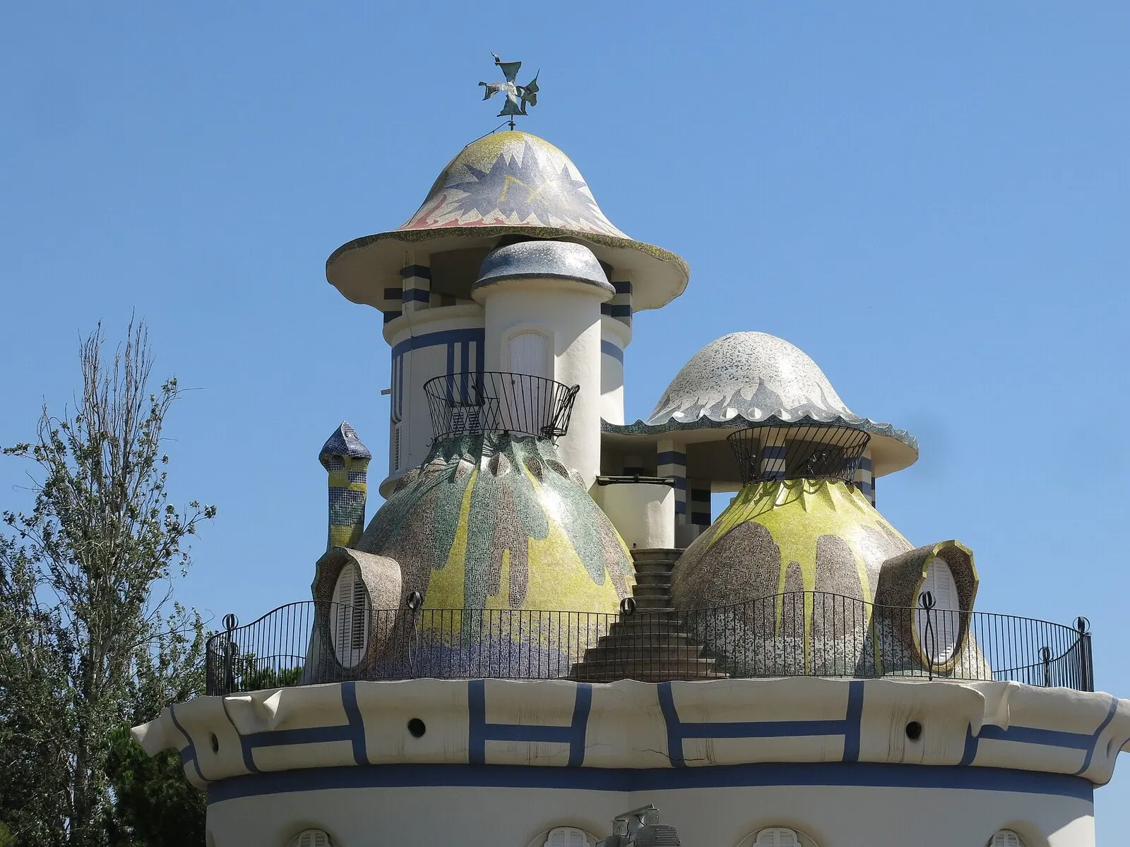 Cúpulas de mosaico de la Torre de la Creu de Jujol en Sant Joan Despí, blancas, azules y amarillas, contra el cielo azul