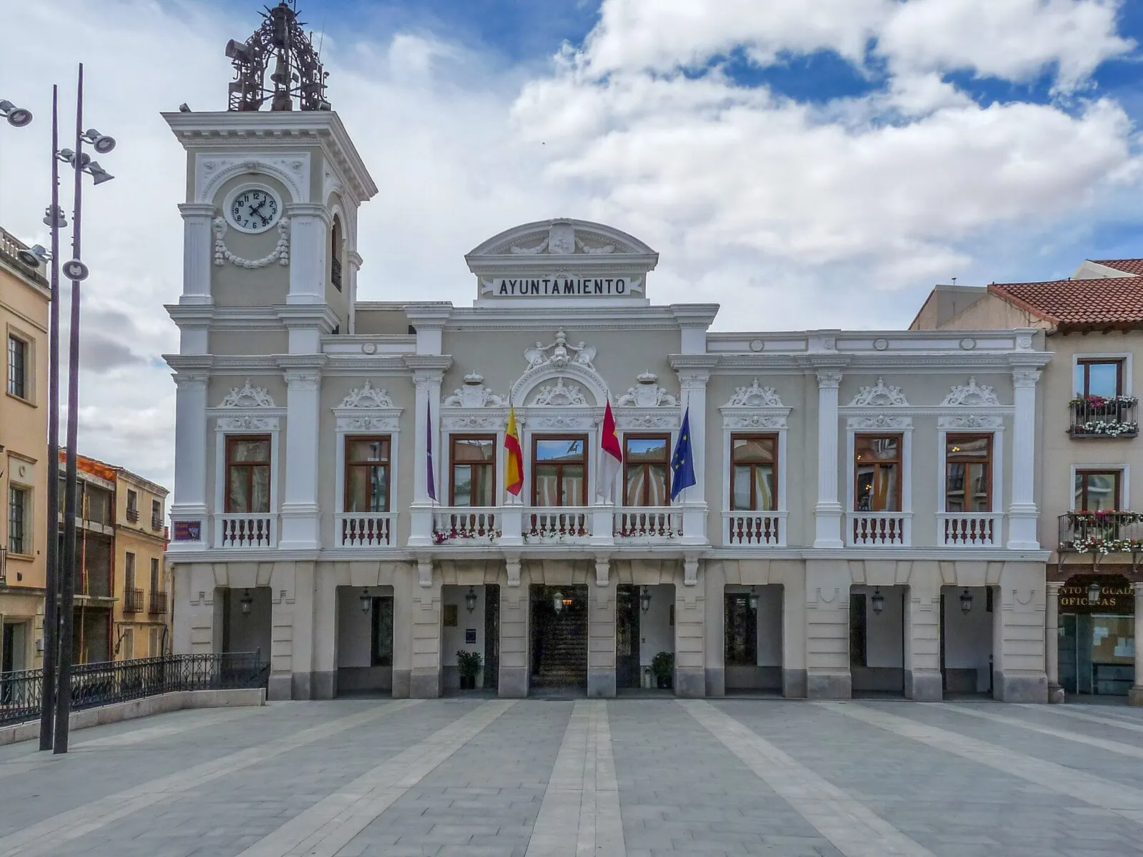 Fachada blanca del Ayuntamiento de Guadalajara con su torre del reloj, vista desde la Plaza Mayor