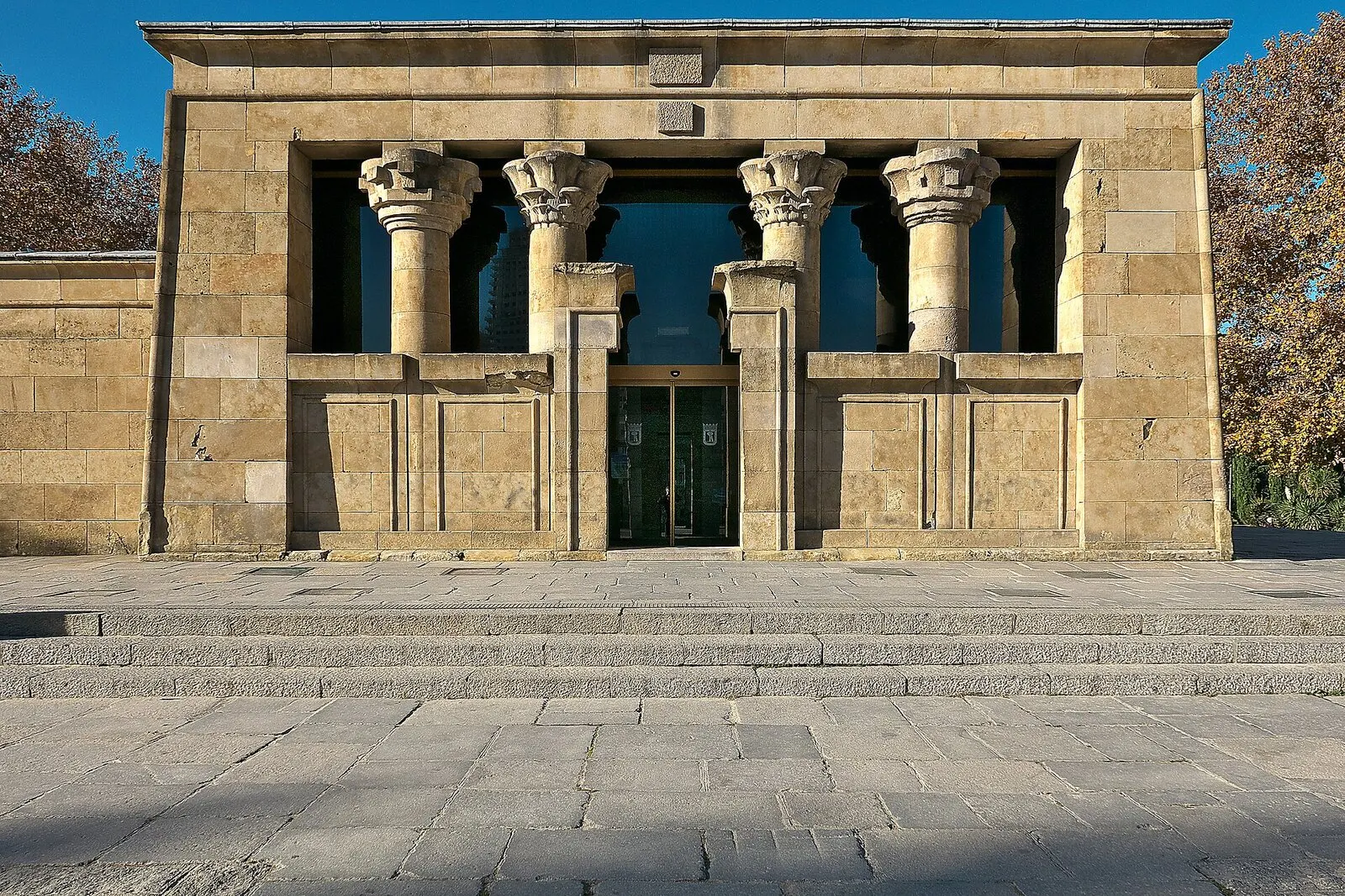 Fachada principal del Templo de Debod, con cuatro columnas de piedra, bajo un cielo azul