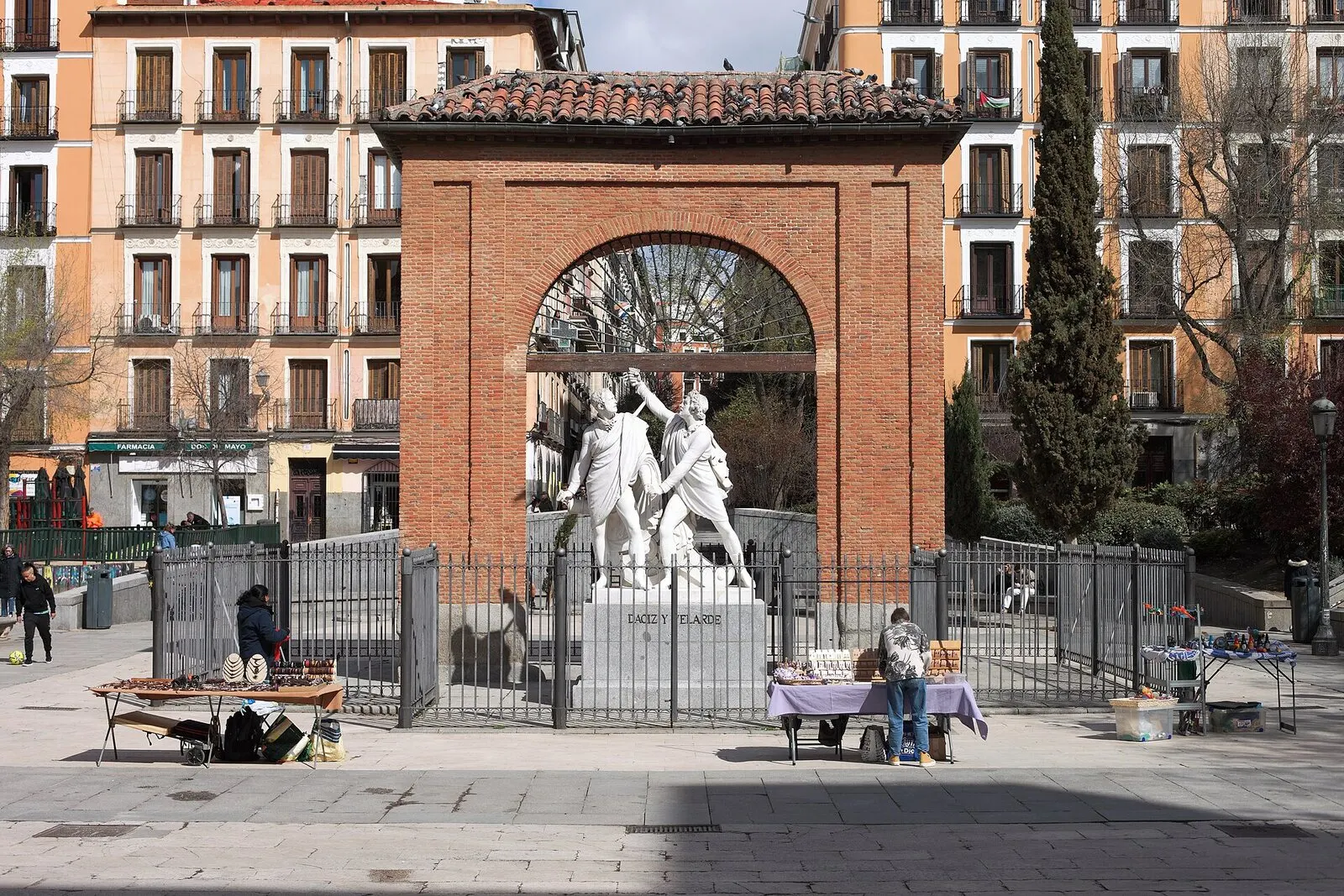 El arco de ladrillo con el monumento a Daoiz y Velarde en la plaza del Dos de Mayo, en Malasaña, de día