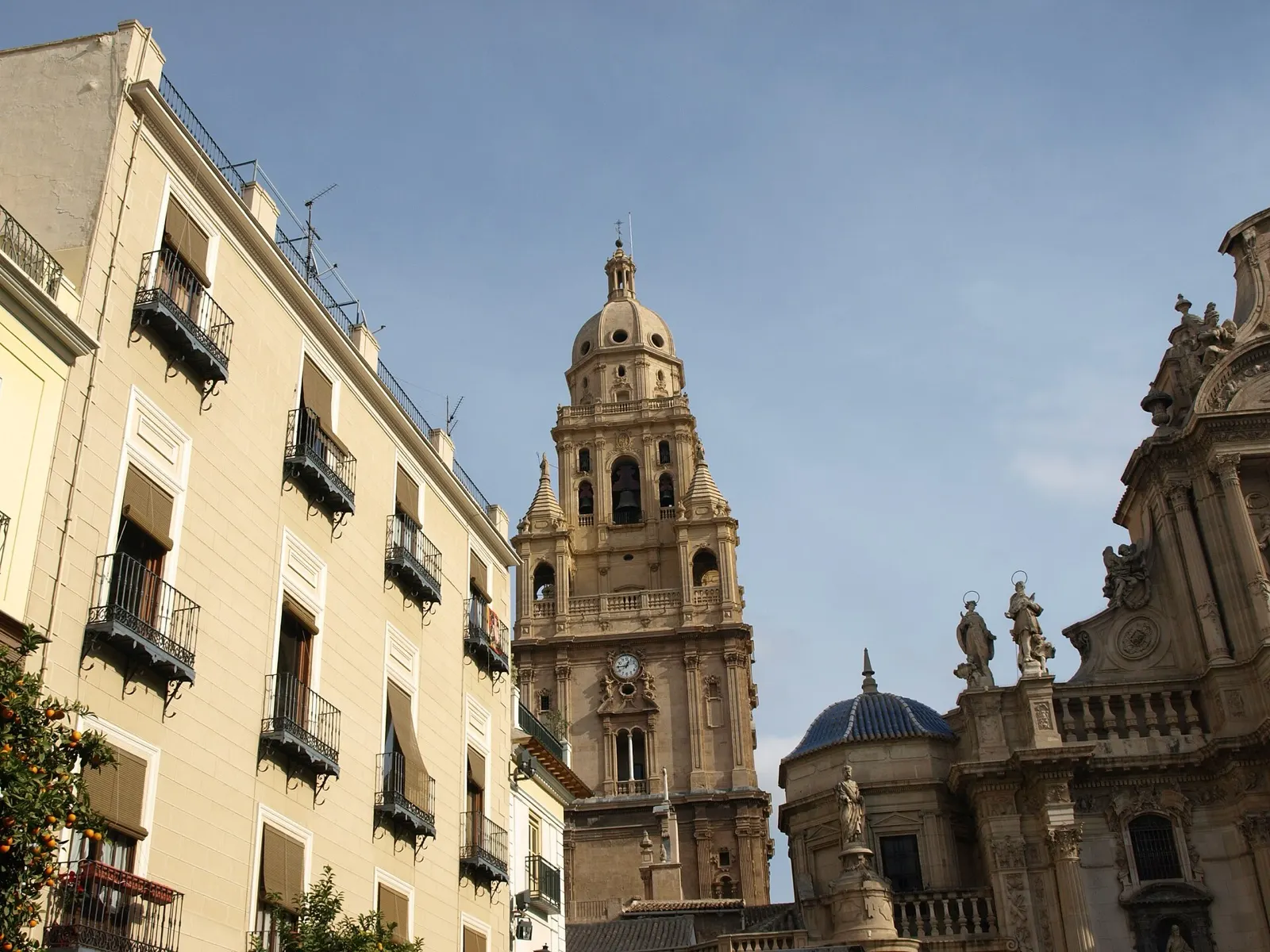 Torre de la catedral de Murcia entre fachadas con balcones, vista desde la plaza del Cardenal Belluga