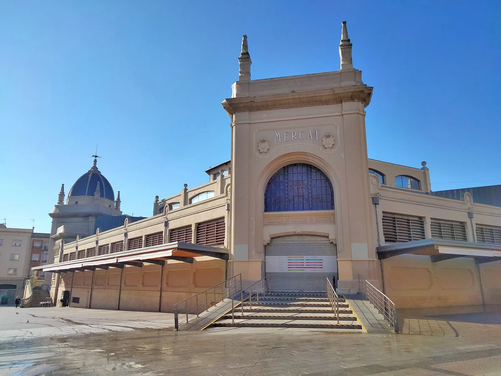 La portada del Mercat Central de Sabadell, con su gran arco y la cúpula al fondo, en una mañana soleada