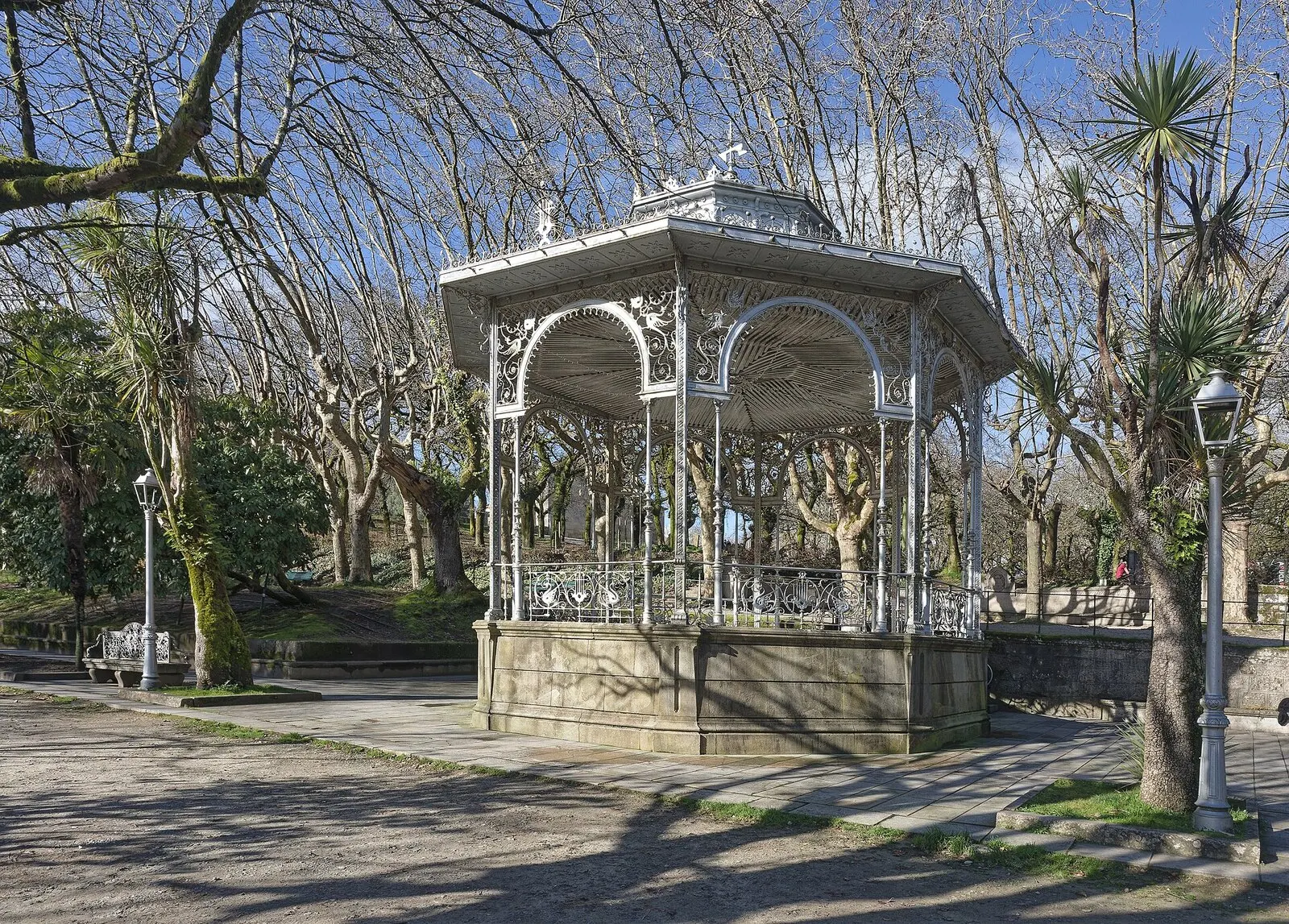 El palco de la música de hierro blanco en el parque de la Alameda, entre plátanos sin hojas en un día soleado