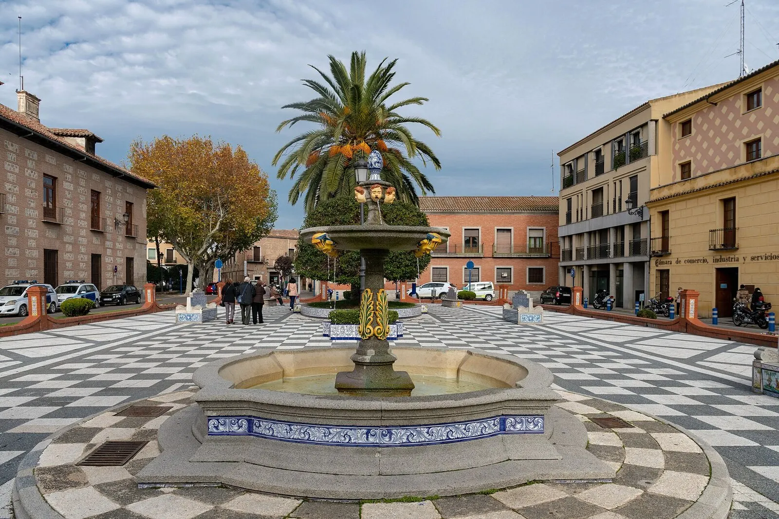 La fuente de la plaza del Pan con su palmera y el suelo ajedrezado, rodeada de fachadas del centro