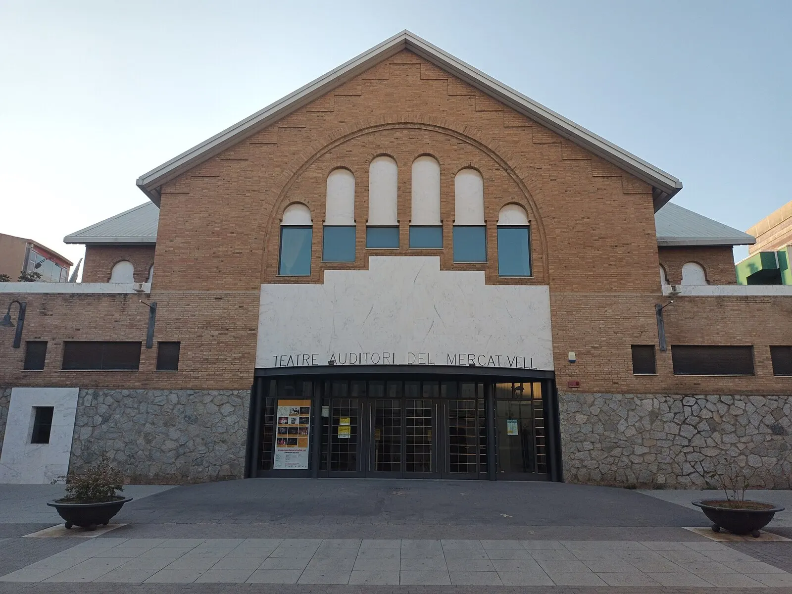 El edificio de ladrillo del Mercat Vell de Ripollet, hoy teatro auditorio, con su frontón y ventanales en arco