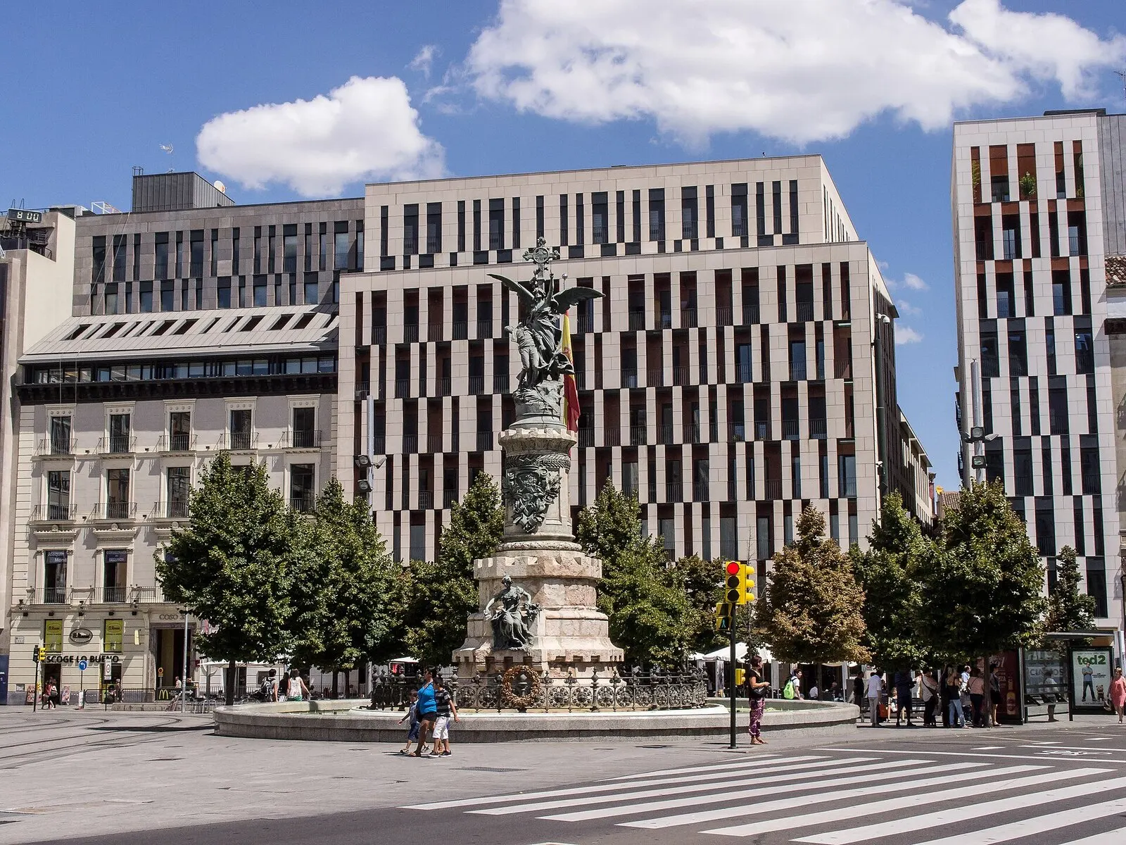 El monumento a los Mártires en la plaza de España de Zaragoza, ante edificios del centro, en un día soleado